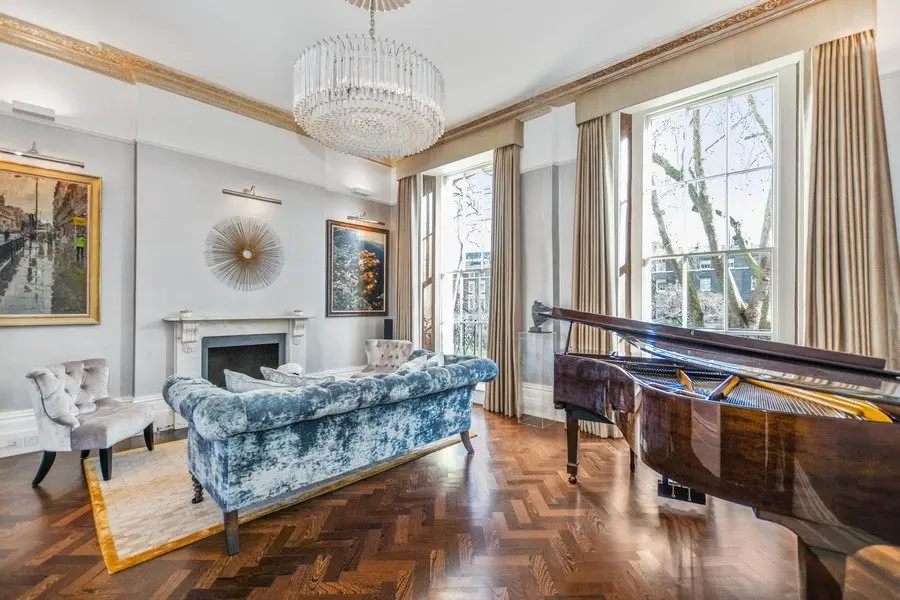 Elegant period living room with a grand piano and chandelier