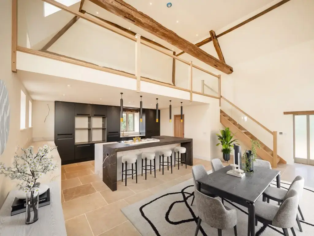 Bright open-plan barn conversion kitchen and dining space with exposed beams